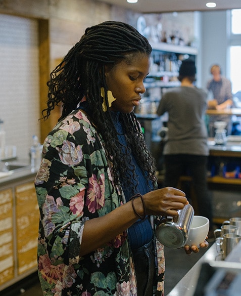 Janelle Johnson pours a latte at Blueprint Coffee Delmar.