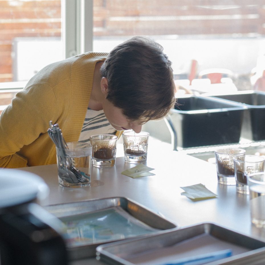 A taster smells freshly ground coffee to evaluate its fragrance during a cupping.