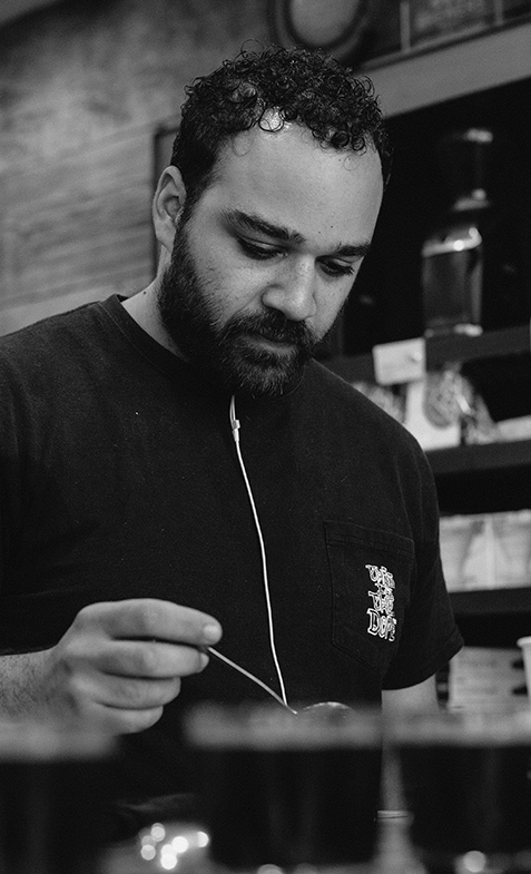 Mazi tastes the results of his roasts using the cupping method.