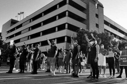 People holding up their fists at a protest in St. Louis.