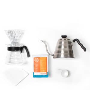 The items in a v60 brew kit. Dripper, carafe, bag of tekton, pouring kettle.