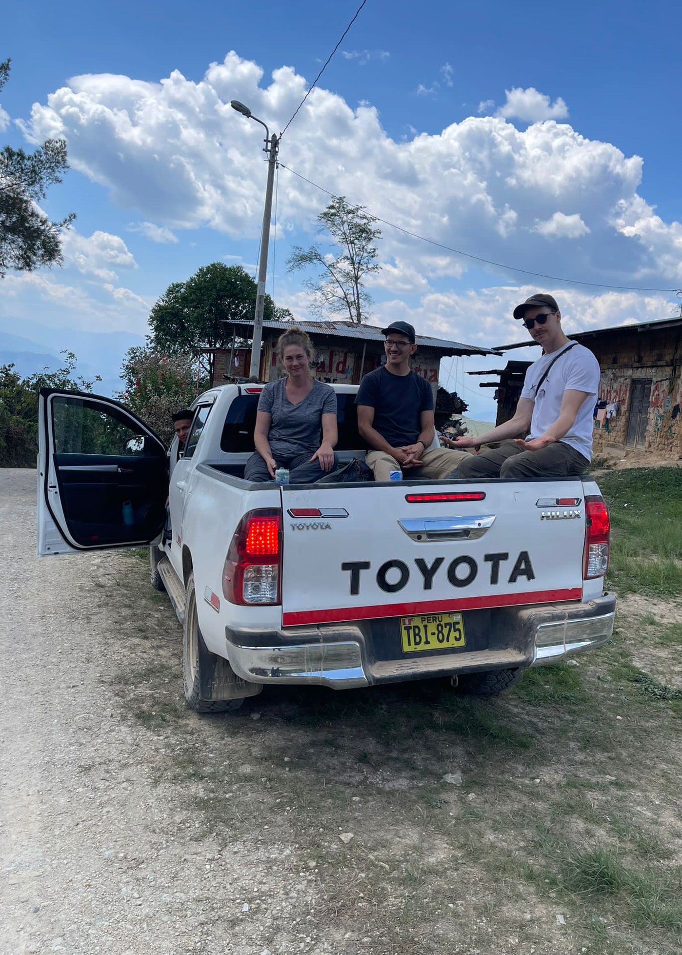 Cher Denny and companions sit in the back of a 4-wheeled truck for the trip up to some coffee farms in Cajamarca.