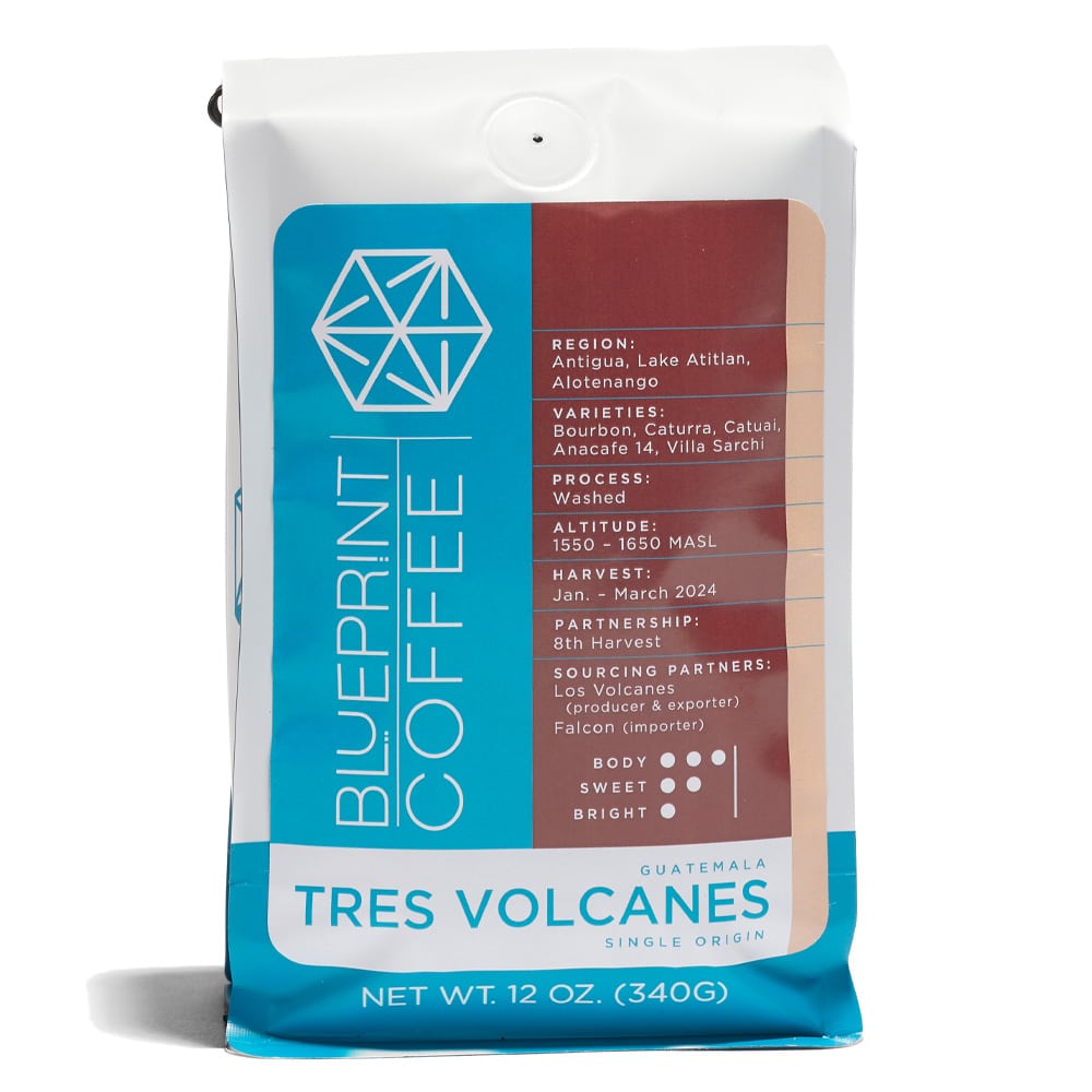 A 12-ounce bag of Tres Volcanes, Guatemala coffee beans with a brown, cream, and blue label containing coffee stats and the Blueprint Coffee logo.