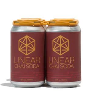 A 4-pack of Linear Chai soda cans held together by a yellow paktek.