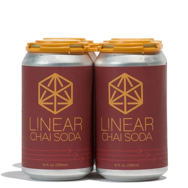 A 4-pack of Linear Chai soda cans held together by a yellow paktek.