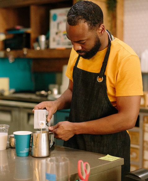 El Profile 10 El Strickland pours milk into a coffee