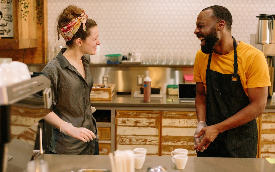 El Profile 14 Two members of the Blueprint Coffee Delmar team face each other while laughing