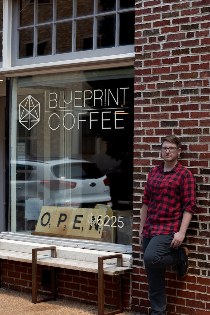 T leans against the brick wall in front of our Delmar café