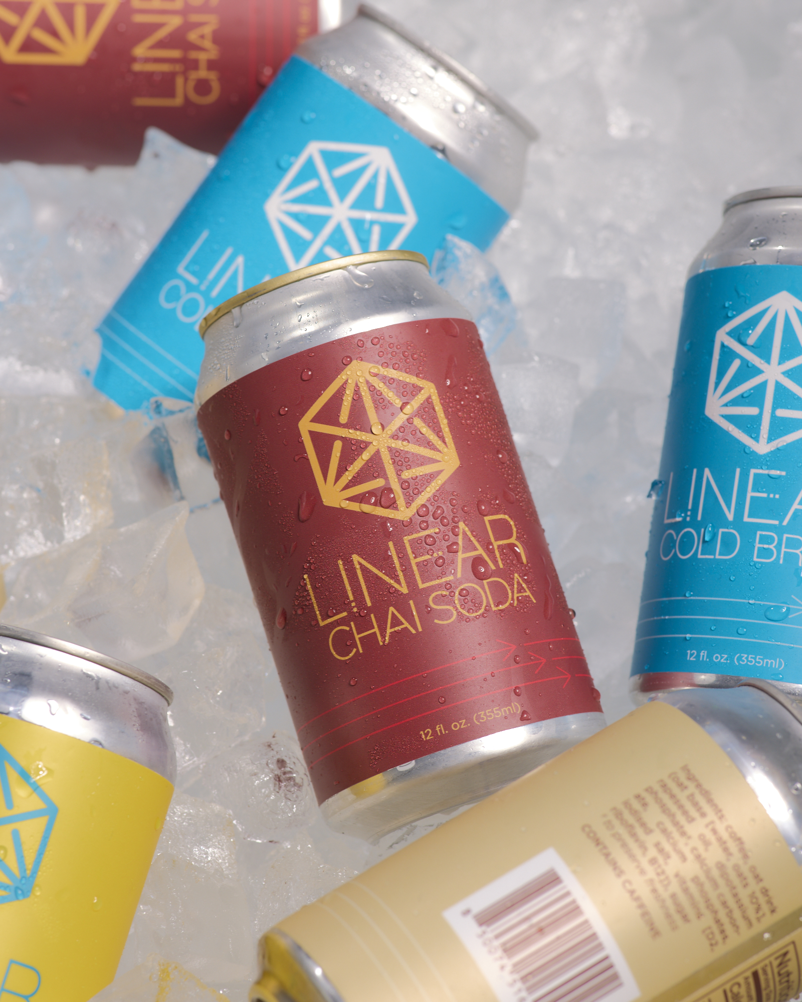 A can of Linear Chai Soda in a cooler full of ice surrounded by cans of Linear Cold Brew, Oat Latte, and Reviver