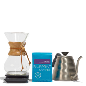 Items from the Chemex kit including (left to right) a 6-cup Chemex brewer atop a Hario drip scale, a bag of Drupe coffee beans, and a Hario Buono kettle.