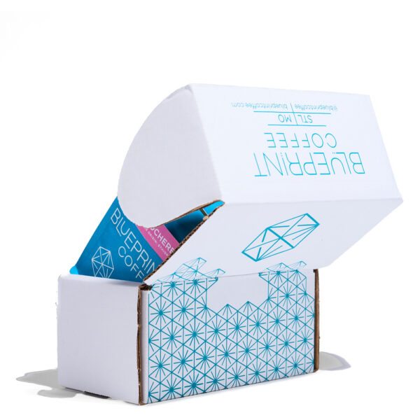 An open sampler box showing a glimpse of a bag of Blueprint Coffee.