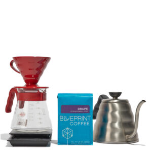 Some of the items form the v60 kit including (left to right) a v60 dripper atop a carafe, a bag of Drupe Coffee beans, and a Buono kettle