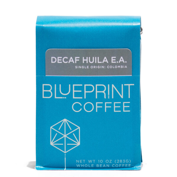 A blue 10-ounce bag of Decaf Huila EA, Colombia coffee beans featuring the Blueprint Coffee Logo and a removable info card.