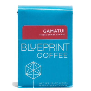 A blue 10-ounce bag of Gamatui, Uganda coffee beans featuring the Blueprint Coffee Logo and a removable info card.