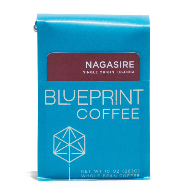 A blue 10-ounce bag of Nagasire, Uganda coffee beans featuring the Blueprint Coffee Logo and a removable info card.