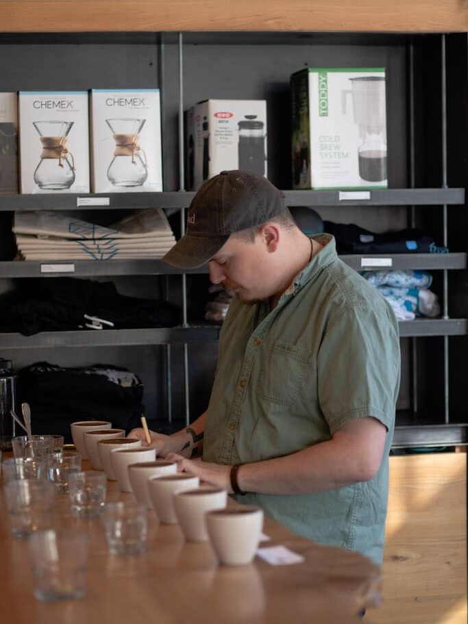 A barista cups coffee at the cupping table at Blueprint Coffee.
