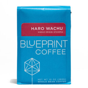 A blue 10-ounce bag of Haro Wachu, Ethiopia coffee beans featuring the Blueprint Coffee Logo and a red removable info card.