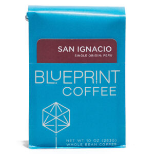 A blue 10-ounce bag of San Ignacio, Peru coffee beans featuring the Blueprint Coffee Logo and a red removable info card.