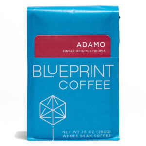 A blue 10-ounce bag of Adamo, Ethiopia coffee beans featuring the Blueprint Coffee Logo and a red removable info card.