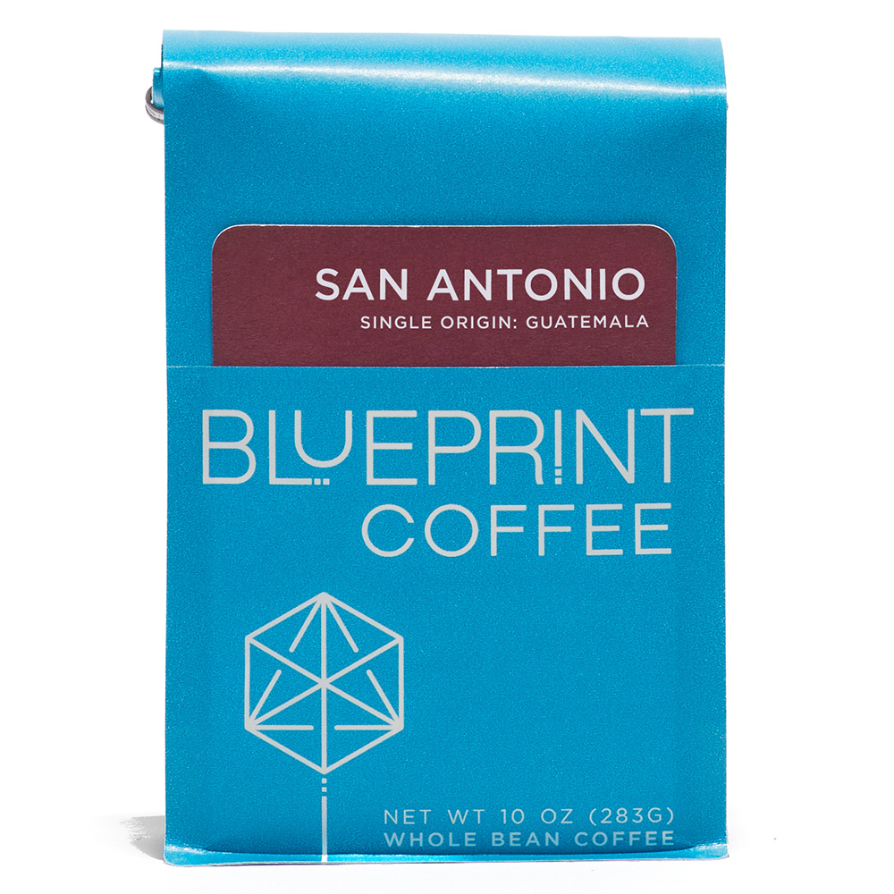 A blue 10-ounce bag of San Antonio, Guatemala coffee beans featuring the Blueprint Coffee Logo and a maroon red removable info card.